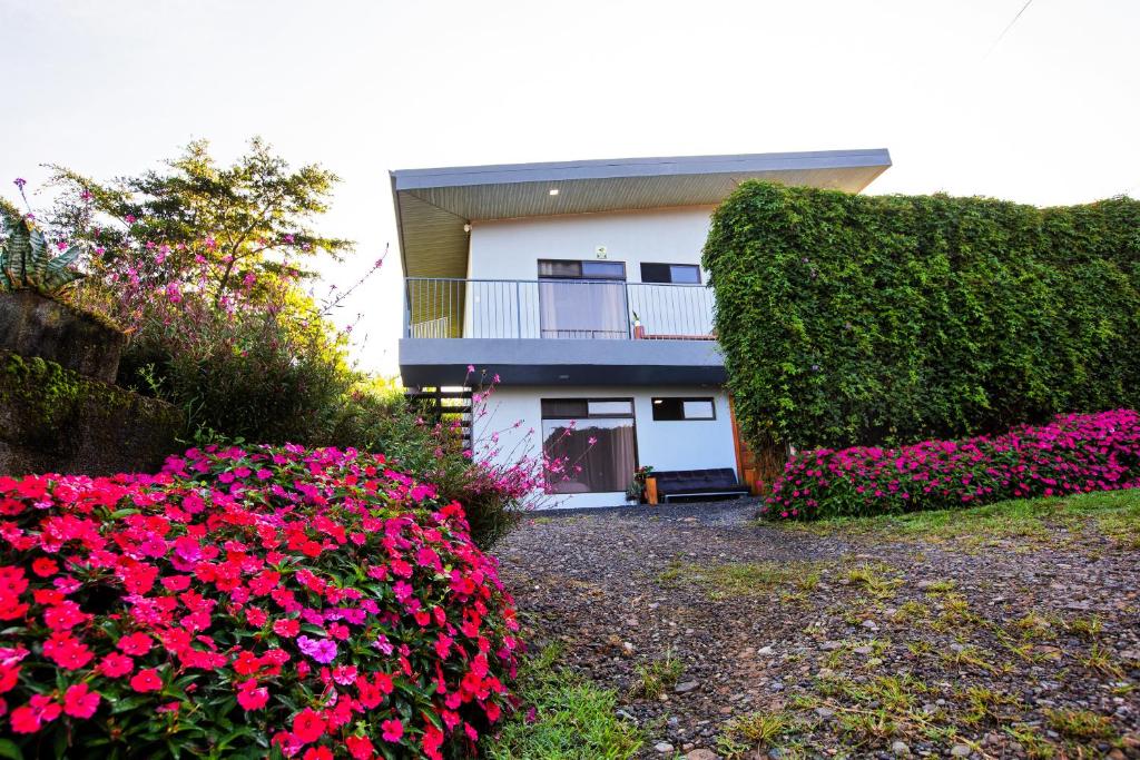 ein Haus mit rosa Blumen davor in der Unterkunft Apartamento Lantana in Monteverde Costa Rica