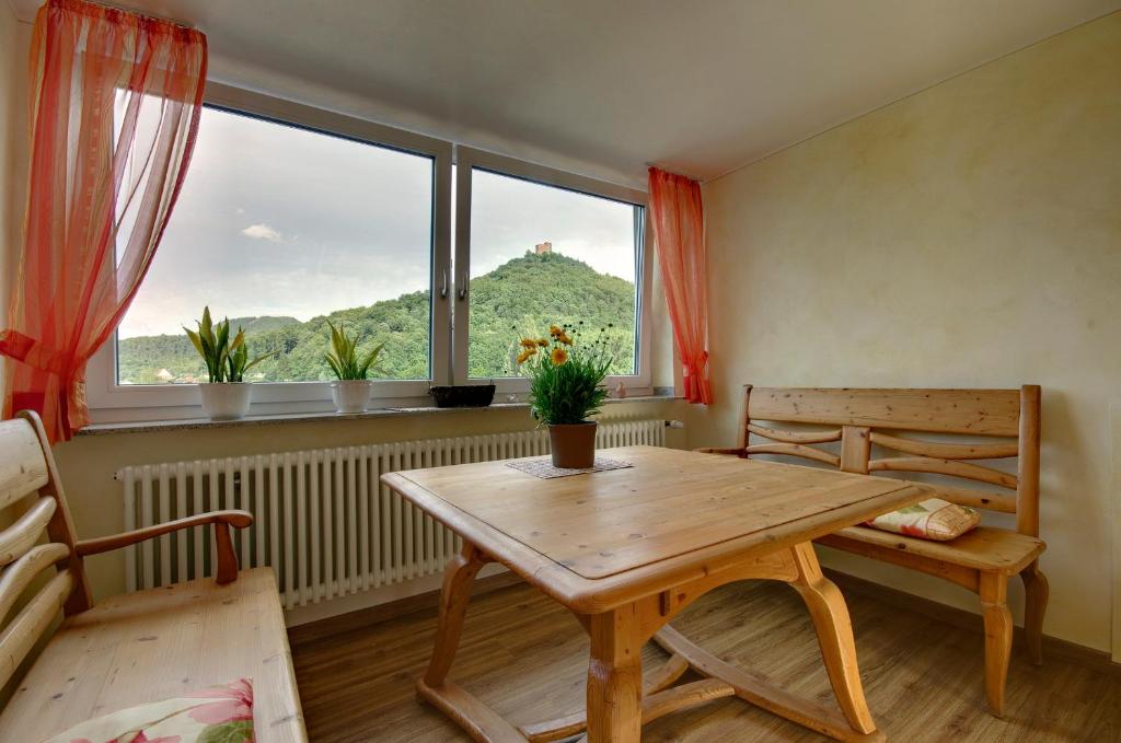 アンヴァイラー・アム・トリフェルスにあるPanorama-Fewo Töpferの木製テーブル、ベンチ、窓が備わる客室です。