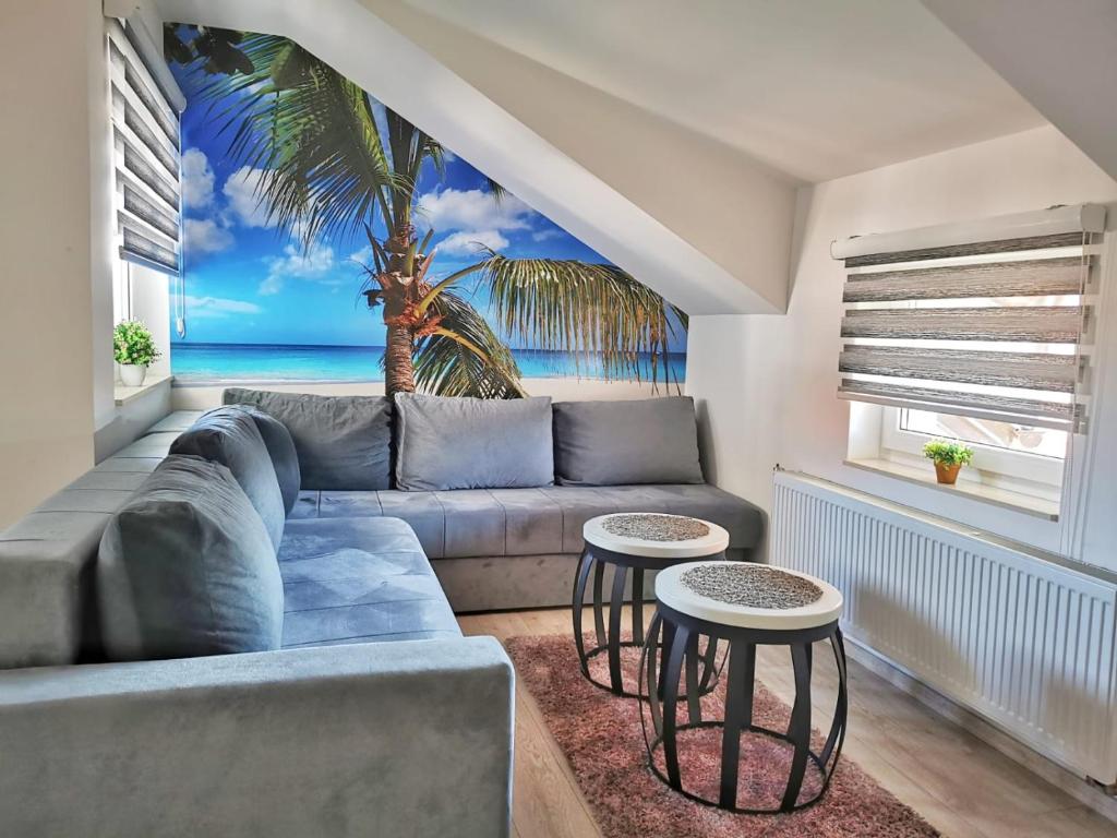 a living room with a couch and a palm tree mural at Apartman Ananas Banja Luka centar bolnica besplatan parking in Banja Luka