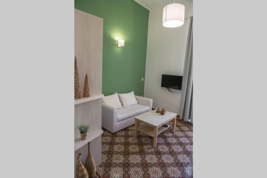 a living room with a white couch and a tv at The Little big apartment in the heart of Heraklion in Heraklio