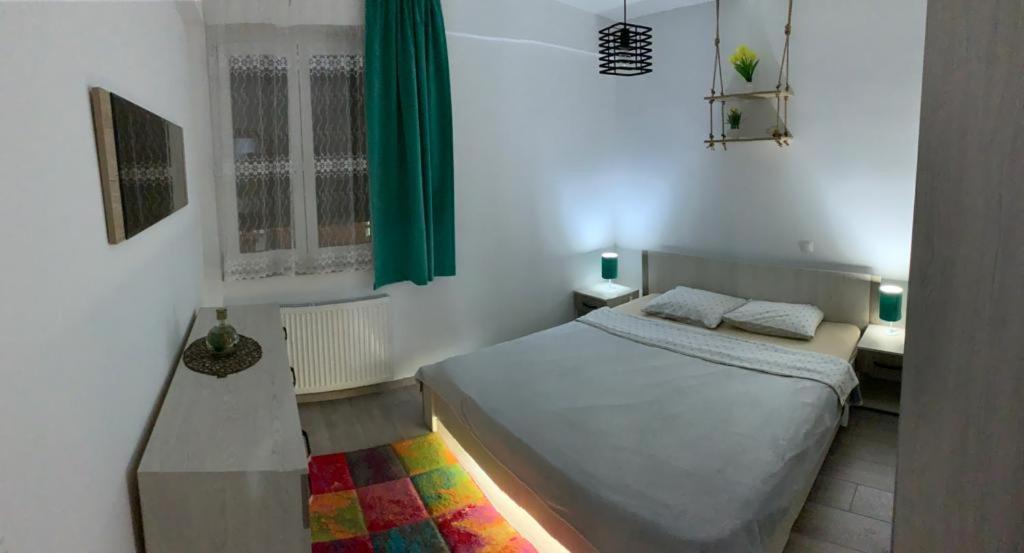 Dormitorio pequeño con cama y mesa en Apartman "Park", en Livno