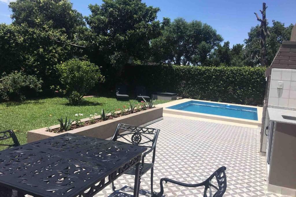 - une table et des chaises noires à côté de la piscine dans l'établissement Ramallo Casa Grande, à Ramallo