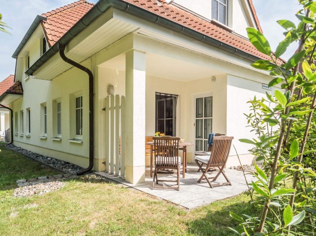 a house with a patio with two chairs and a table at Birkenstraße 11c, FeHa 1 in Zingst