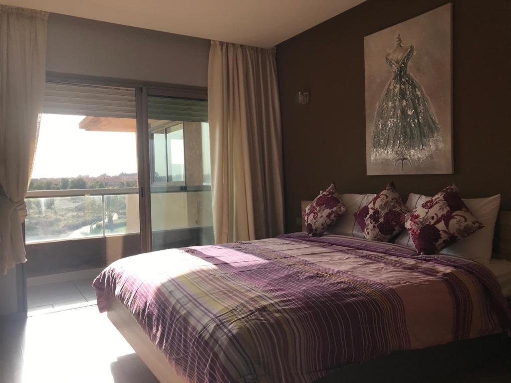 um quarto com uma cama com um vestido na parede em Luxury apartment Prestigia em Marrakech
