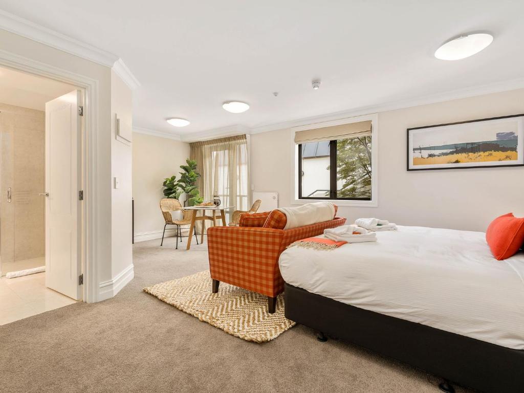 a bedroom with a bed and a living room at Central Luxury at 407 The Beacon Studio in Queenstown