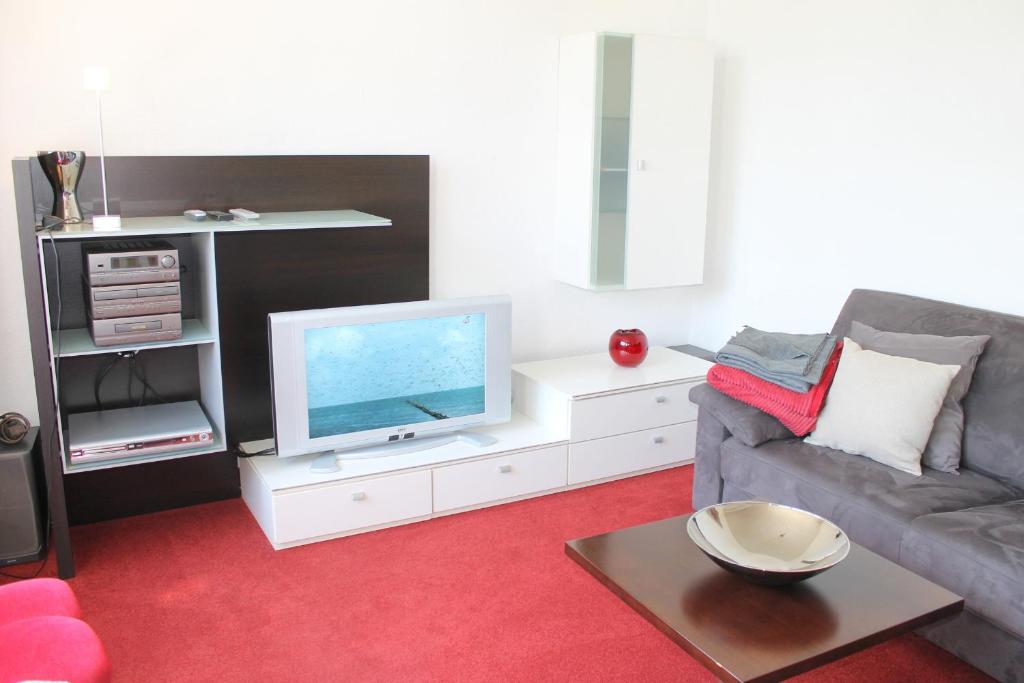 a living room with a couch and a tv at "Das Sonnendeck" - mit 2 Schlafzimmern, ruhig und strandnah gelegen in Grömitz