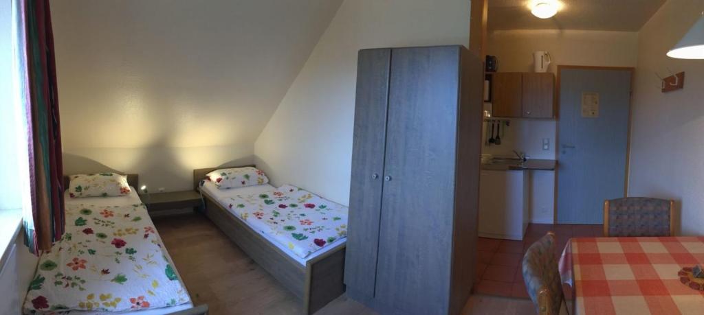 Habitación pequeña con 2 camas y cocina en zum Zander, en Wester-Ohrstedt