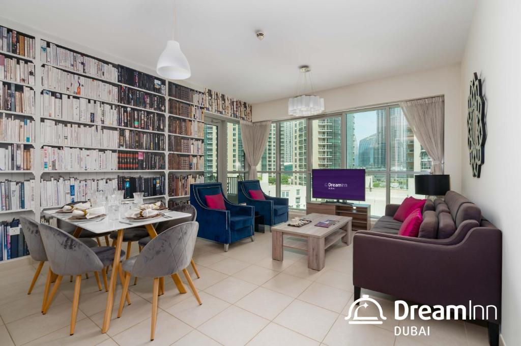 - un salon avec une bibliothèque dotée d'une table et de chaises dans l'établissement Dream Inn Apartments - Boulevard Central, à Dubaï