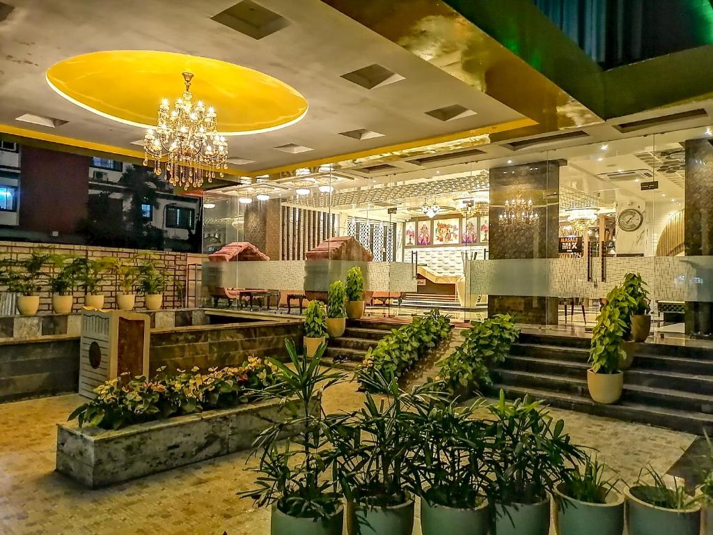 a restaurant with potted plants and stairs in a building at Ghar 365 Residency in Guwahati