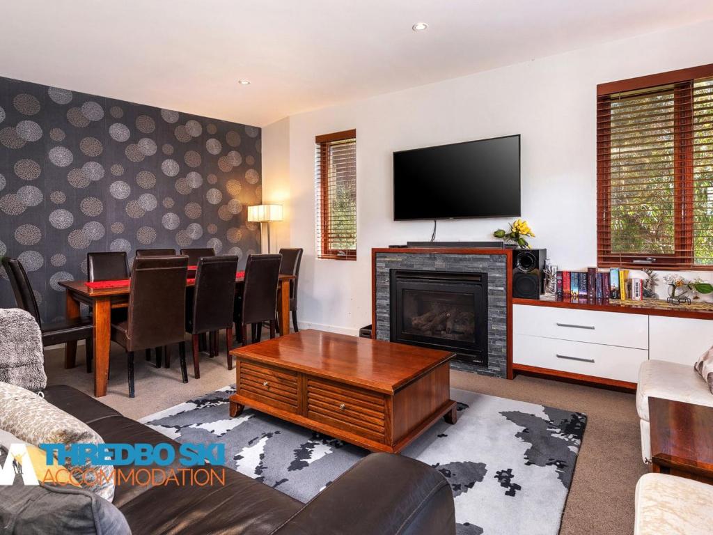a living room with a fireplace and a tv at Elevation 5 in Thredbo