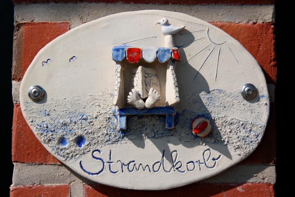 un panneau sur le côté d'un mur de briques dans l'établissement Ferienwohnung "Strandkorb", à Hinrichsdorf