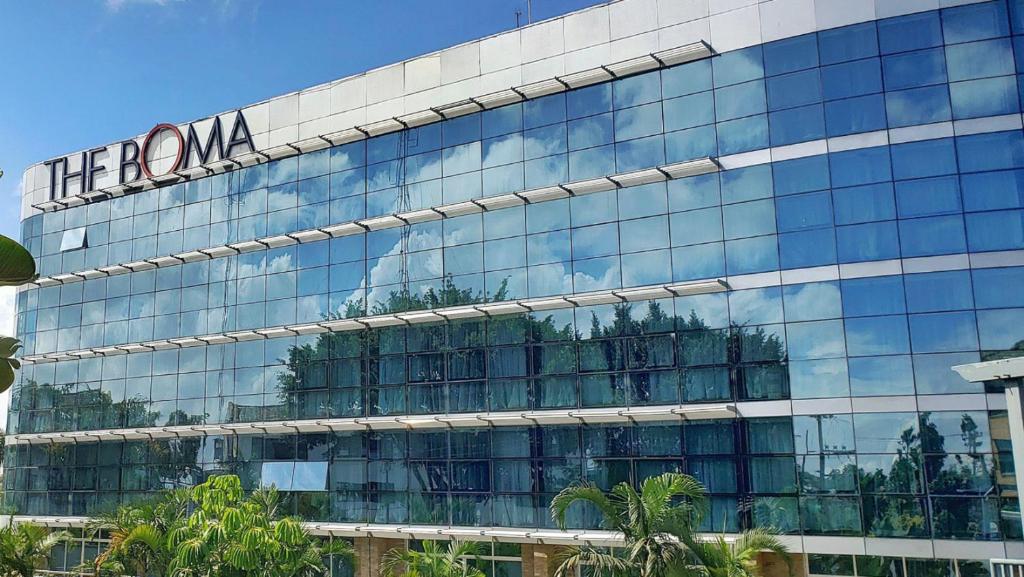 um grande edifício de vidro com uma placa em The Boma Nairobi em Nairobi