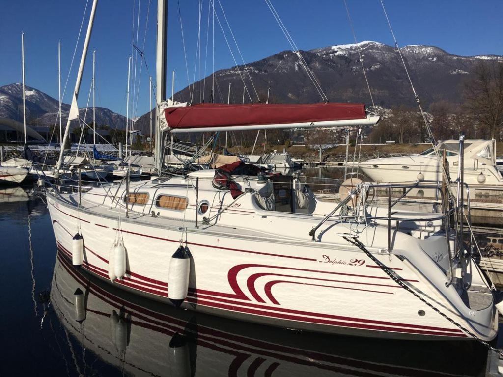 een witte boot is aangemeerd in een jachthaven bij Barca a vela sul lago Maggiore in Locarno