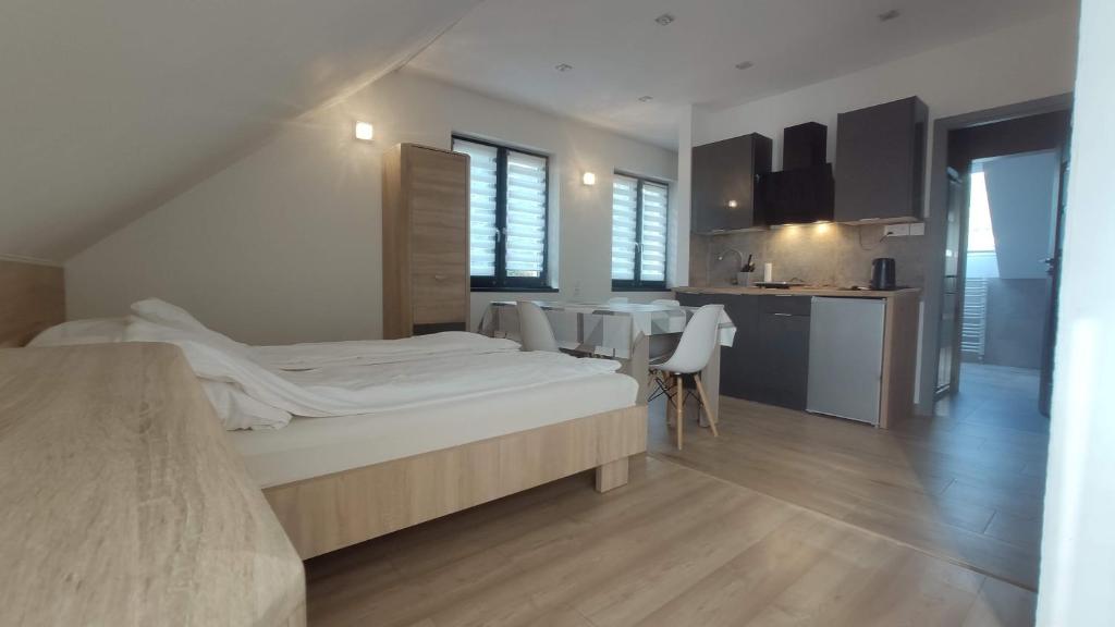 een slaapkamer met een bed en een tafel en een keuken bij APART Magnolia in Międzybrodzie Żywieckie