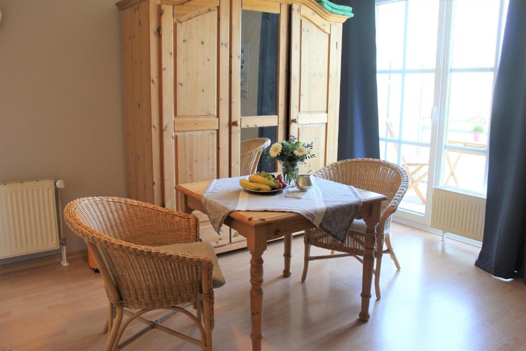 una mesa de comedor con sillas y una mesa con bananas. en "Pappelhof - Whg 6", en Grömitz