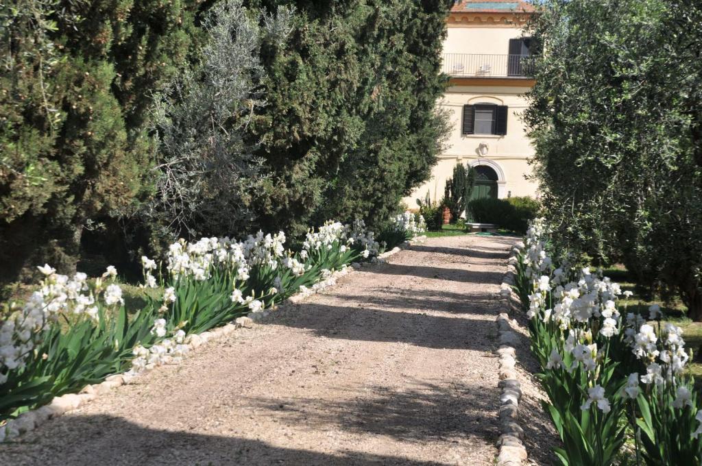 un jardín con flores blancas y árboles y un edificio en Colonna Country Home, en Ururi