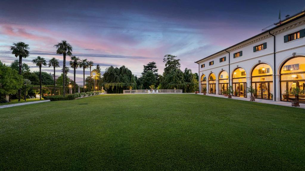 a large lawn in front of a large building at Villa Barchessa Panigai 14, Emma Villas in Cappella Maggiore