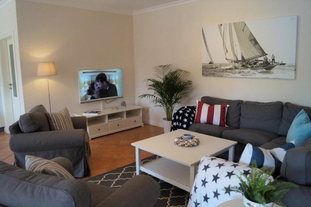 sala de estar con sofás y TV en Wellenläufer en Westermarkelsdorf