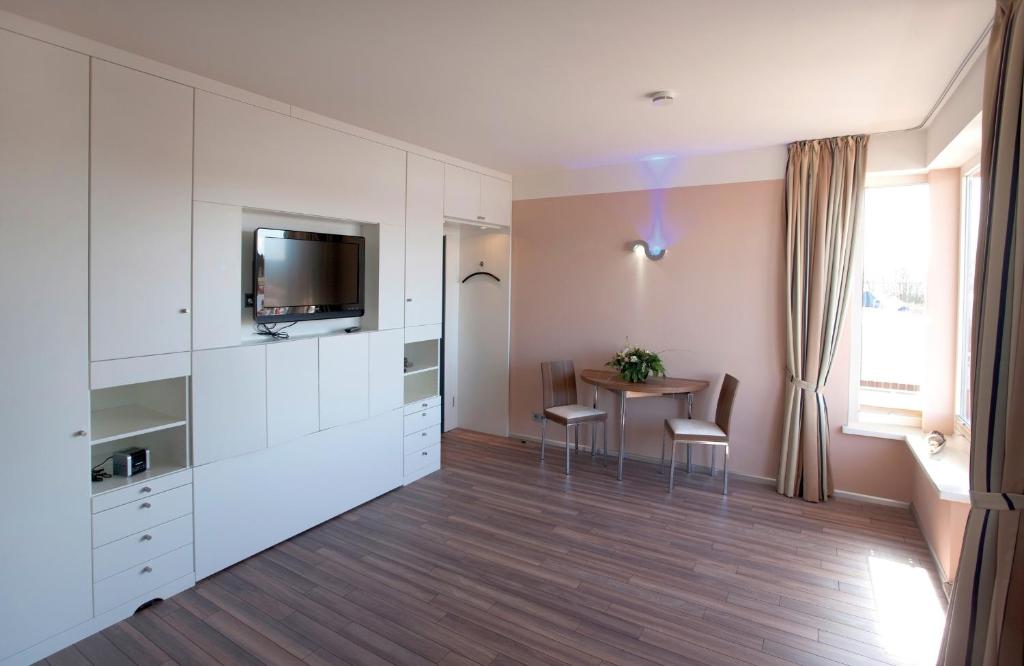 a kitchen with white cabinets and a table with chairs at ancora Marina Haus 2 Nr 04, Typ 1 in Neustadt in Holstein