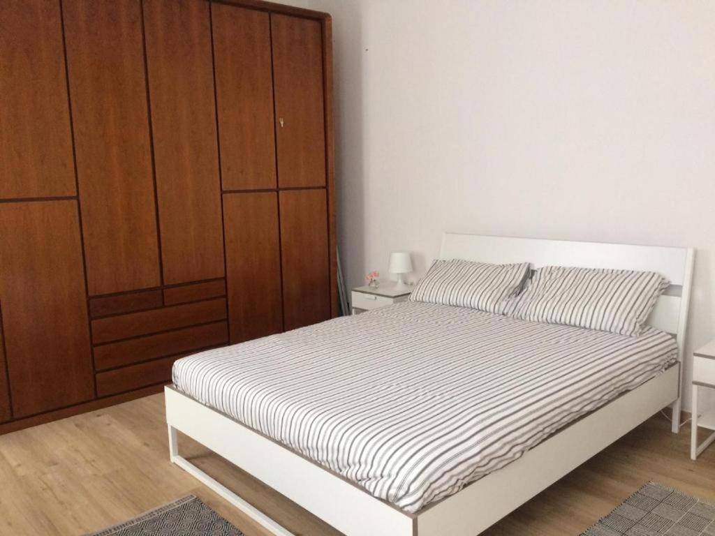 1 dormitorio con 1 cama y armario de madera en Bixio9, en La Spezia