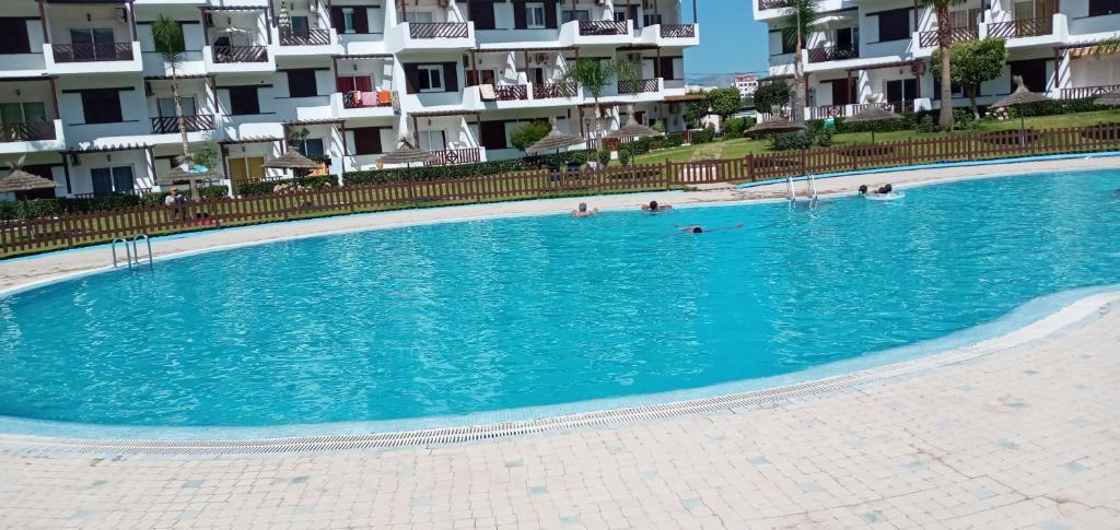a swimming pool in front of some apartment buildings at Studio de luxe avec piscine in Tétouan