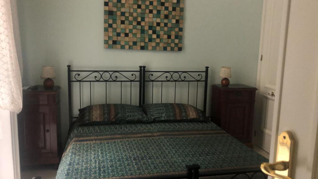 uma cama num quarto com duas mesas de cabeceira e uma fotografia em La stanza di Zeza em Nápoles