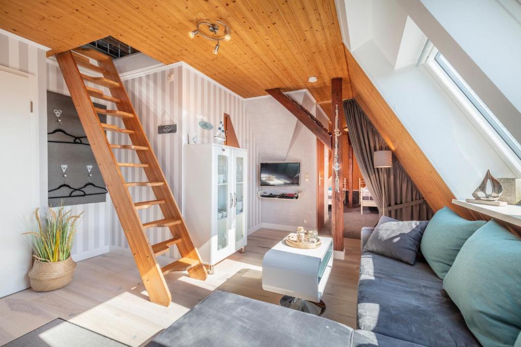 a living room with a staircase and a couch at "Villa Anker" Dachgeschoss - links in Fehmarn