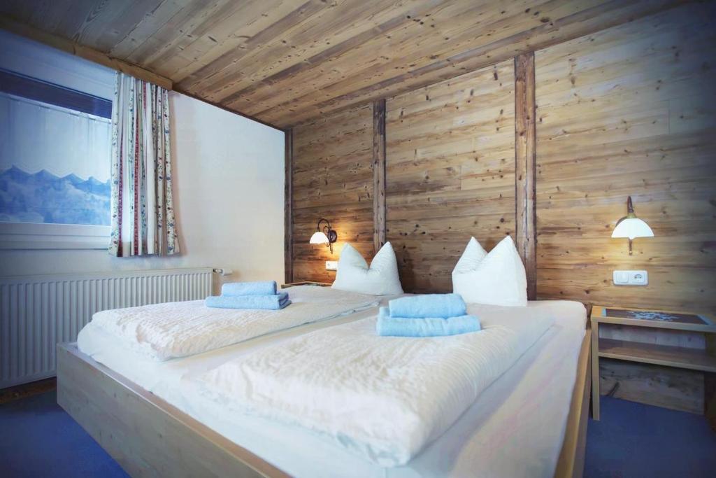 1 dormitorio con 1 cama blanca grande y paredes de madera en Apartments RIFA - Gaschurn, en Gaschurn