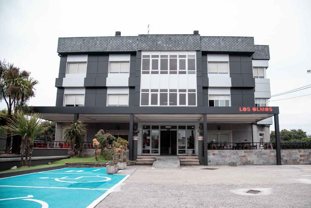 een gebouw met een ons glimlach bord ervoor bij Hotel Los Olmos in Lugo