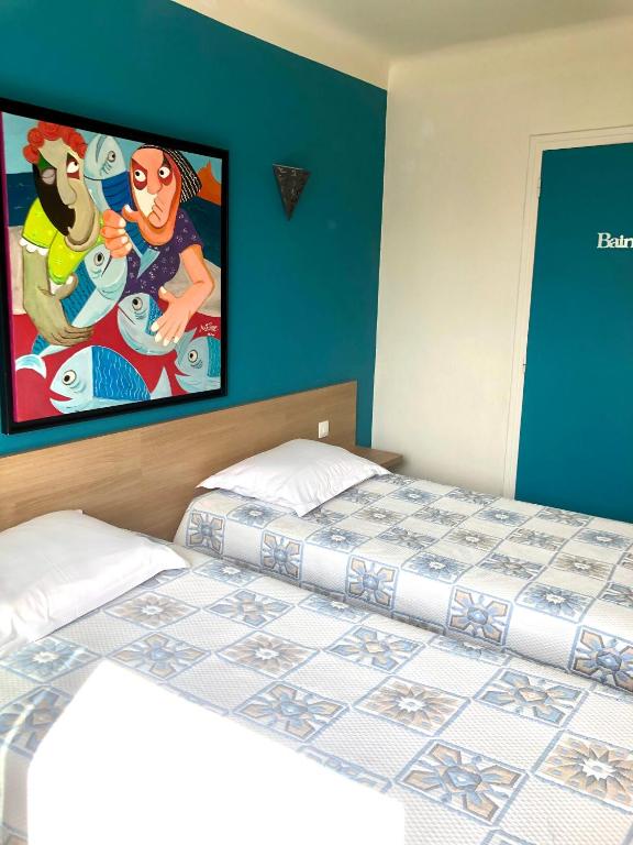 a bedroom with two beds and a painting on the wall at Hôtel Colisée-Verdun Centre Gare Saint-Roch in Montpellier