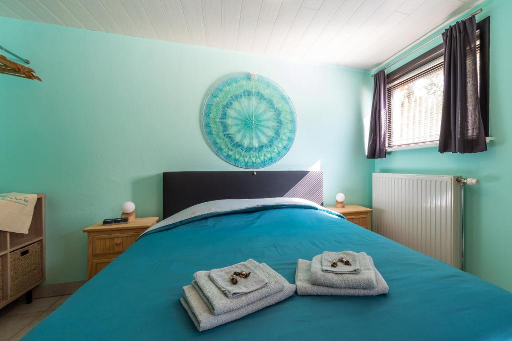 een slaapkamer met een bed met handdoeken erop bij Studio De Groene Golf in Middelkerke