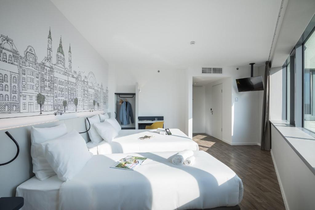 a room with three beds and a couch at B&B Hotel Budapest City in Budapest