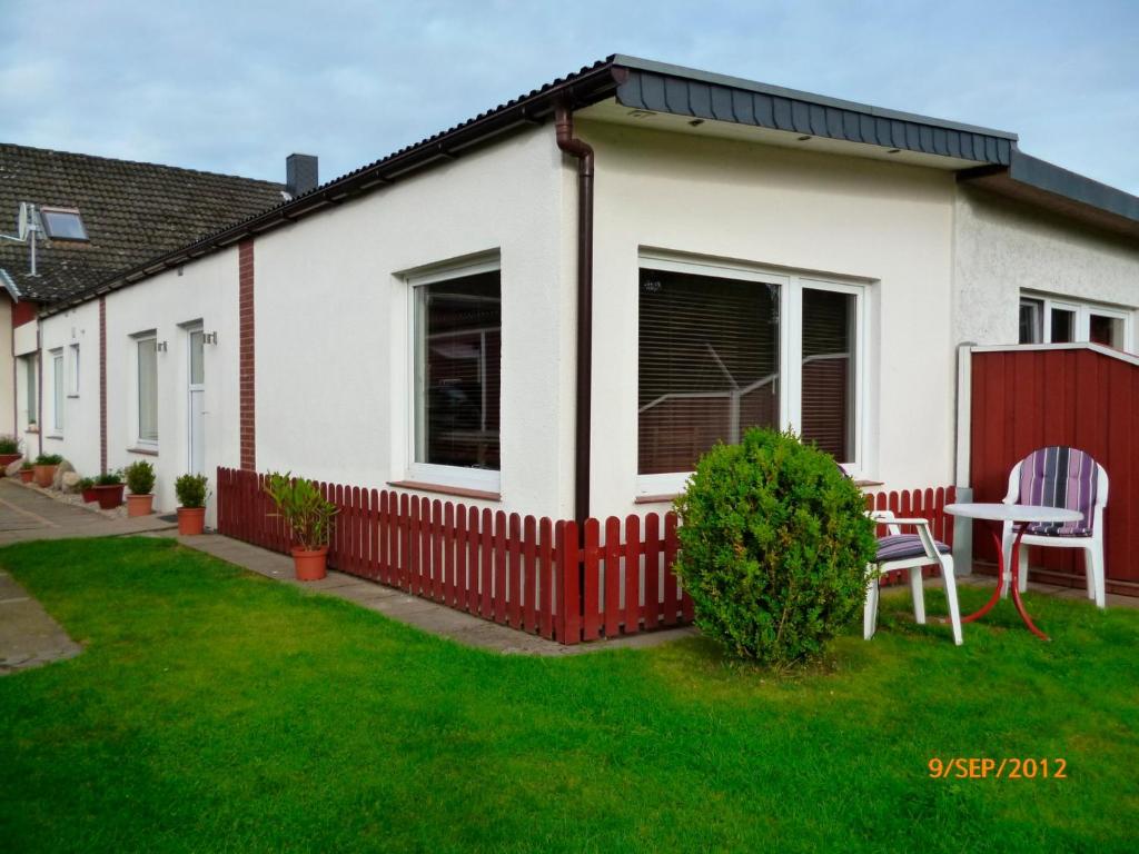 une maison blanche avec une clôture rouge dans l'établissement Ferienwohnung Tietgen, à Rendsburg