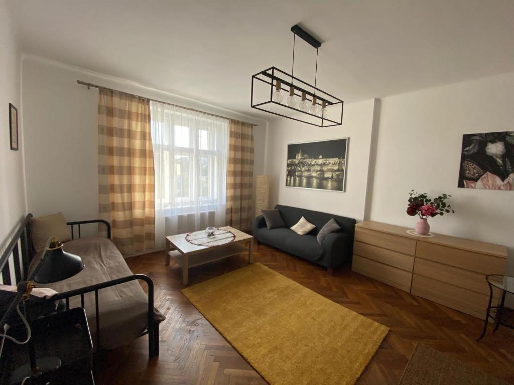 uma sala de estar com um sofá e uma mesa em Apartman Xaveriova em Praga