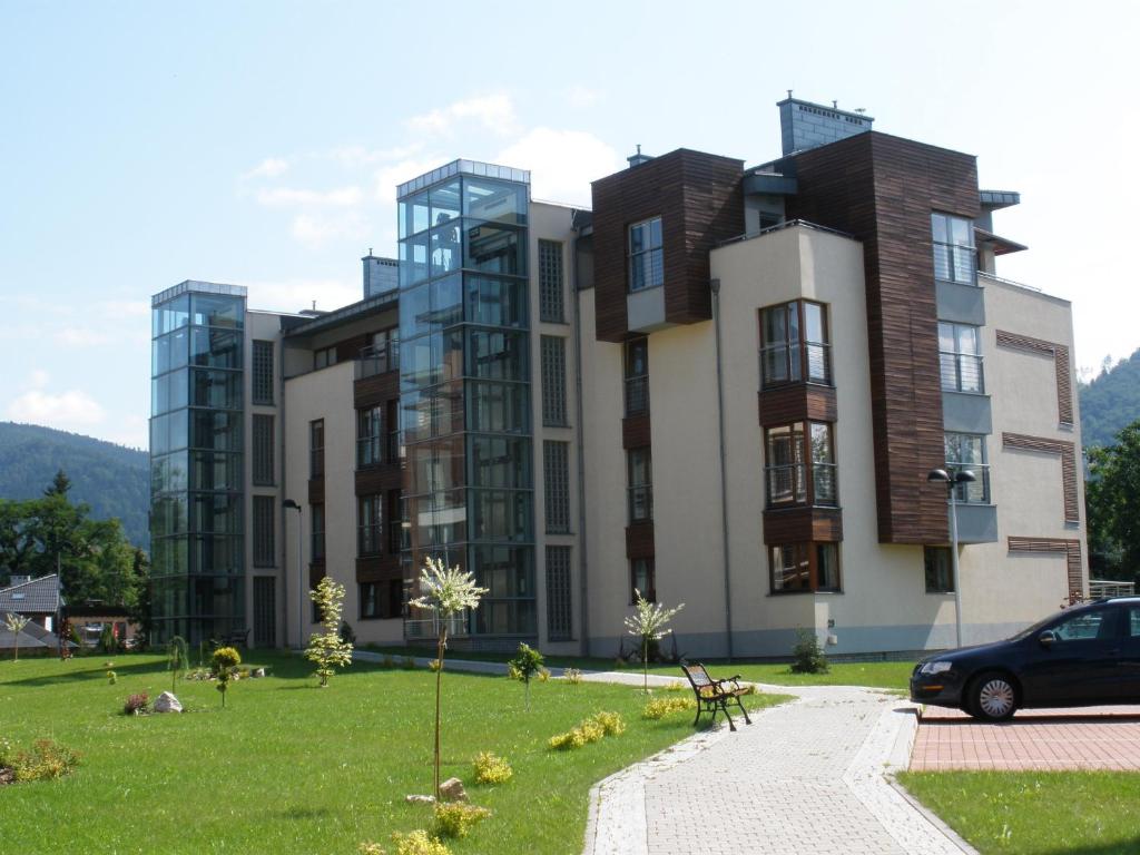een gebouw waar een auto voor geparkeerd staat bij Luksusowy apartament w Ustroniu in Ustroń