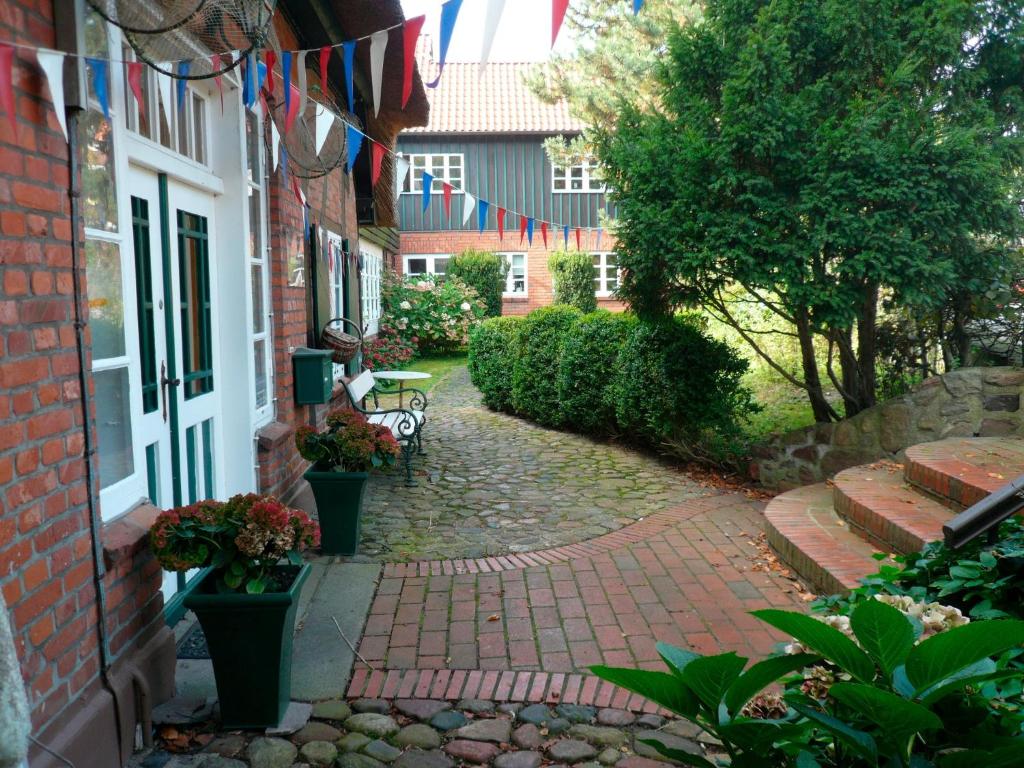 a brick walkway next to a building with flags at Landhaus-Marwede App 2 in Haffkrug