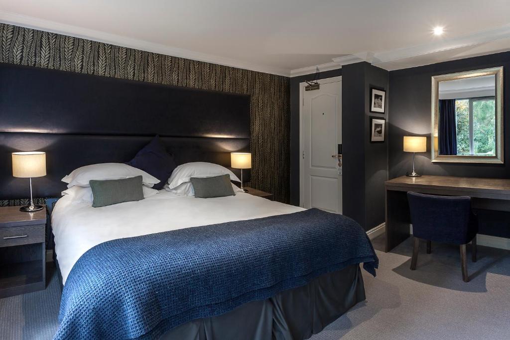 um quarto com uma cama grande e uma secretária em Langdale Hotel & Spa em Ambleside