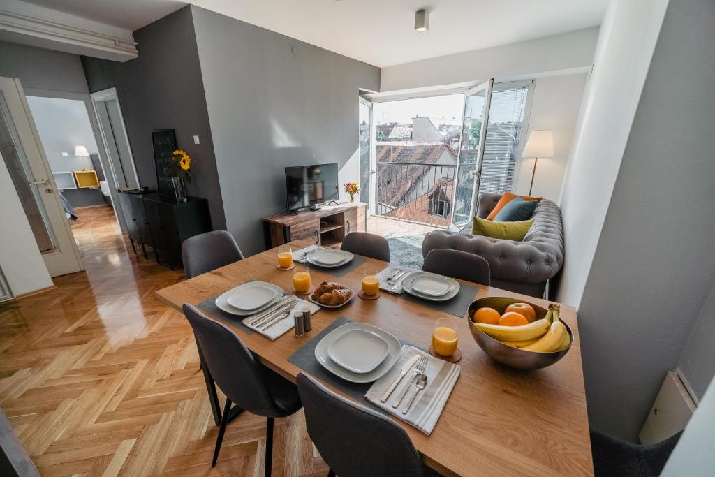 uma sala de jantar e sala de estar com uma mesa de madeira em Lux Apartments em Zagreb