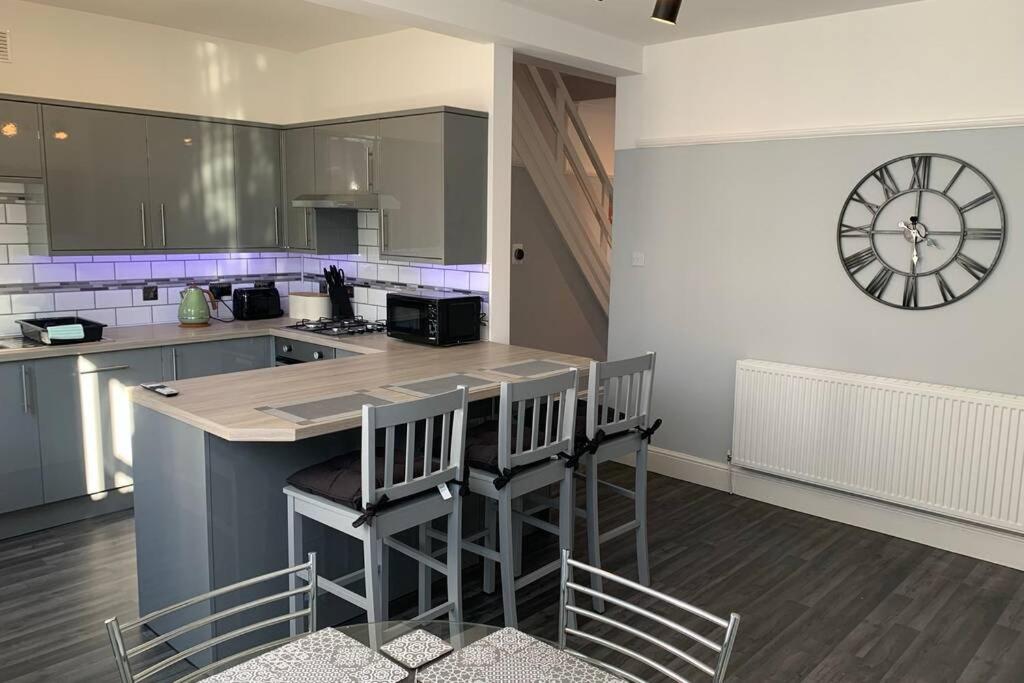 a kitchen with a counter and a clock on the wall at Modern fully refurbished 3 bedroom home in Blackpool