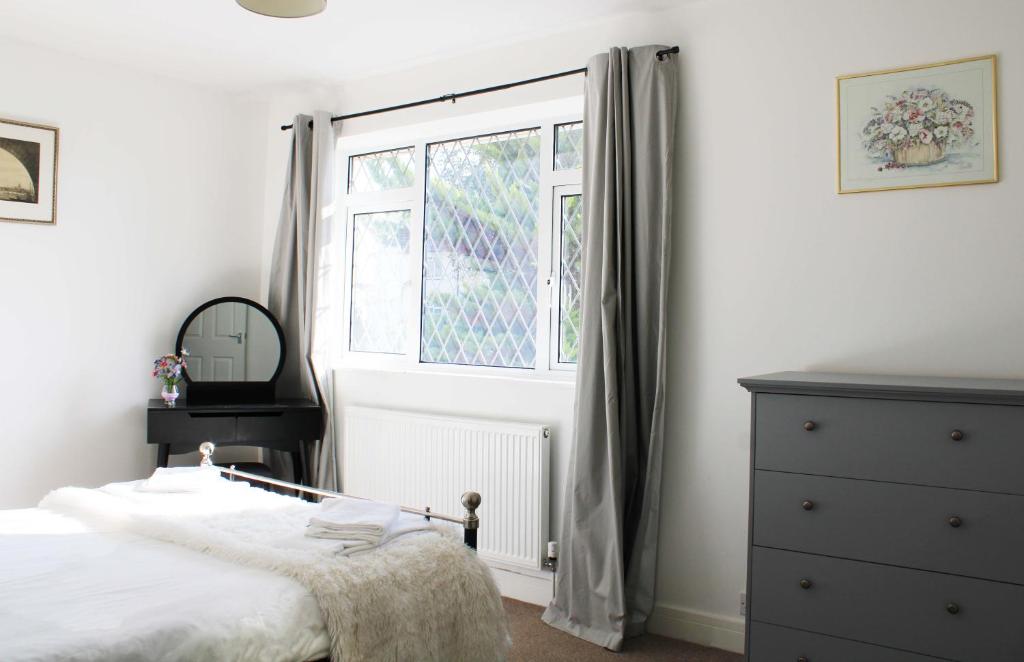 1 dormitorio con cama y ventana en Oxford - Private House with Garden & Parking 05, en Oxford