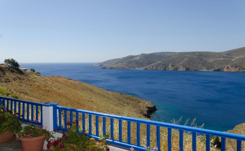 una cerca azul en una colina junto al agua en Provarma, en Astipalea