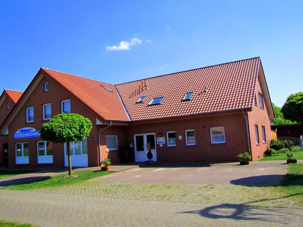 a red brick building with a red roof at Ferienwohnung Mauer, Wohnung "C" in Heede