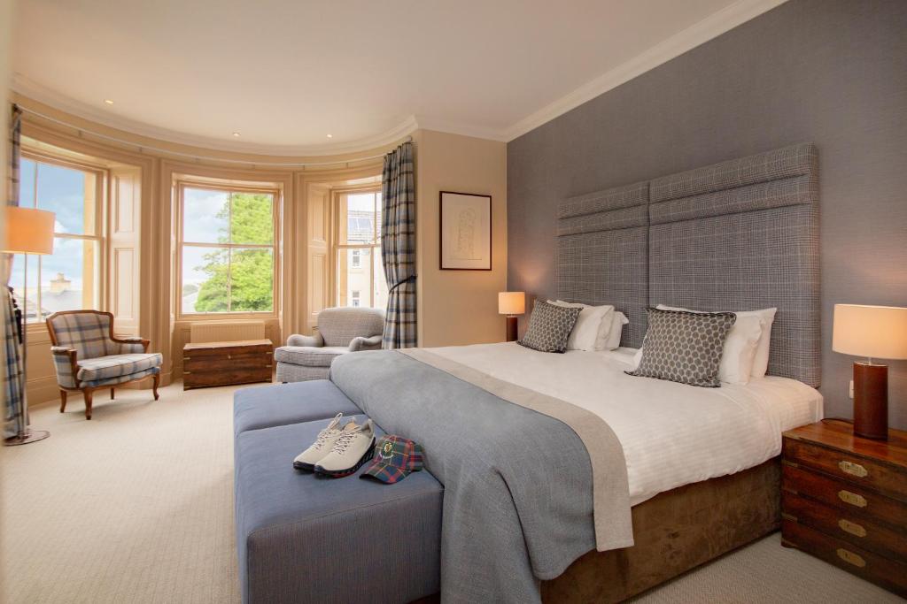 a bedroom with a large bed and a chair at Royal Golf Hotel in Dornoch