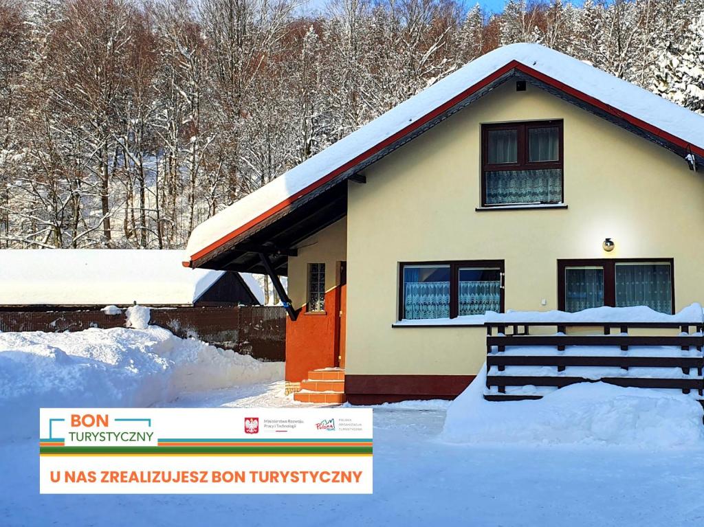 a house with snow on the ground in front of it at Domek Tylko Dla Ciebie in Szczyrk