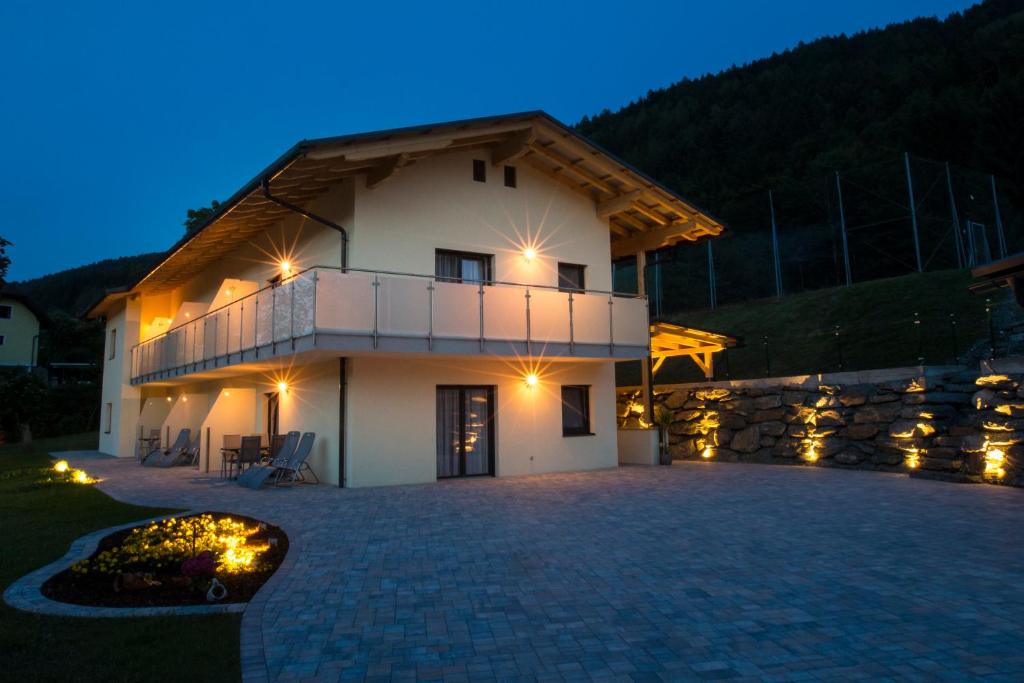 ein großes weißes Haus mit Balkon in der Nacht in der Unterkunft Fischerstüberl in Ossiach