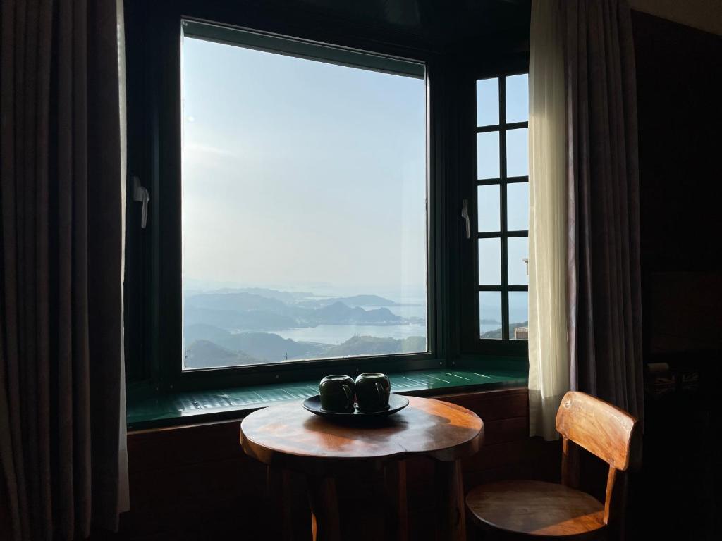 una mesa frente a una ventana con un tazón. en Jing Zhan en Jiufen