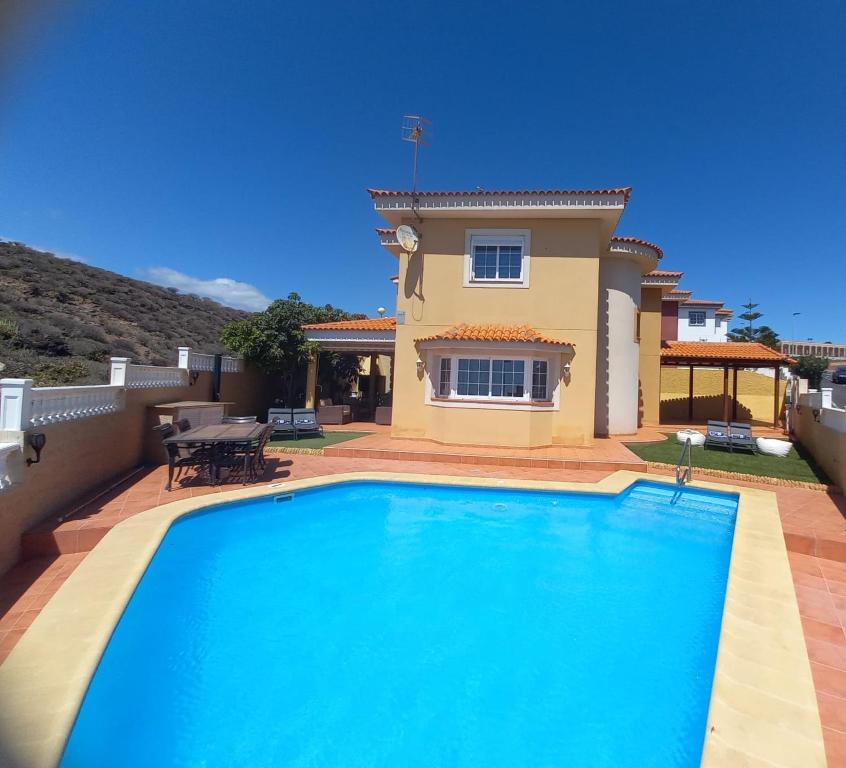 une villa avec une piscine en face d'une maison dans l'établissement Villa Nancy Tenerife Sur, à Granadilla de Abona