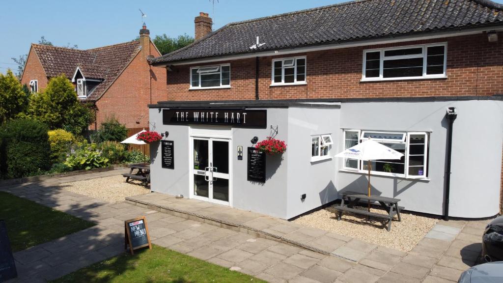 a white building with an umbrella in front of it at The White Hart in Ashill