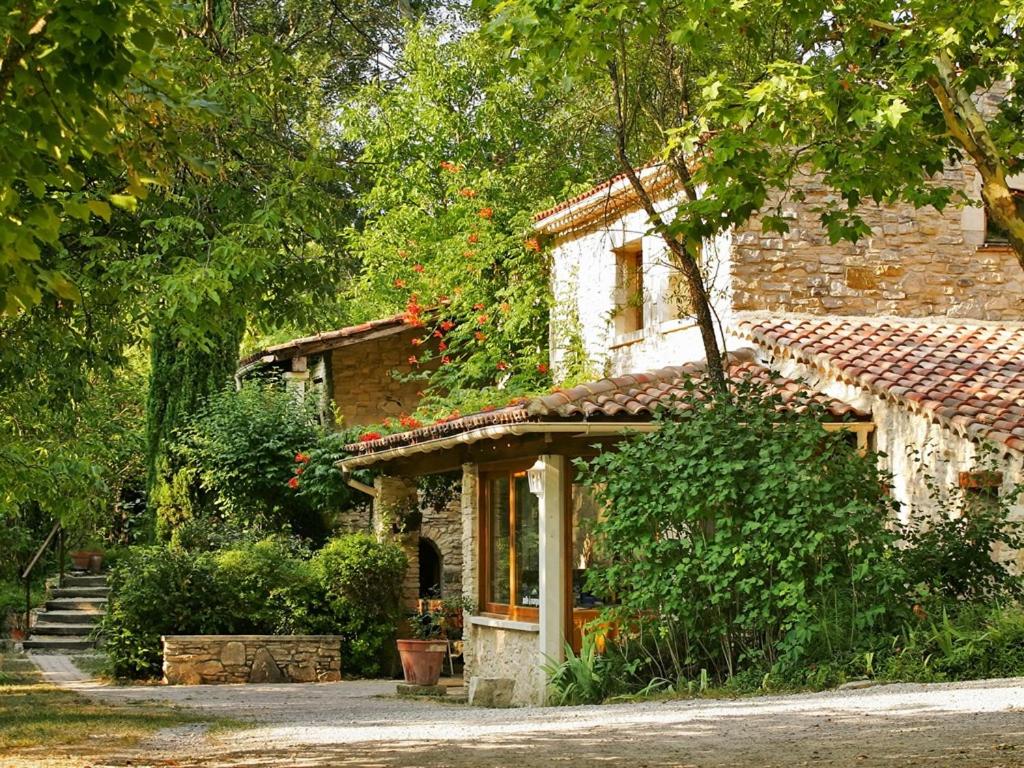 an old stone house in the middle of a yard at Les Maisons De Chante Oiseau in Sigonce