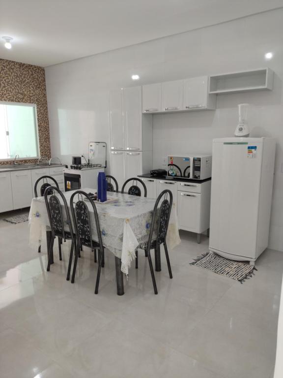 a kitchen with a table and chairs and a refrigerator at Casa do Lamarques in Piranhas